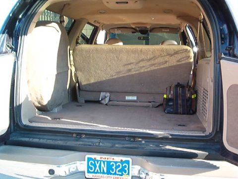 2000 Ford Excursion - The spacious interior cargo area of a 2000 Ford Excursion, a spare tire and folded rear seats, offers ample storage.