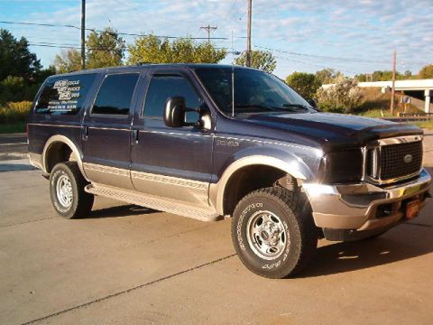 2000 Ford Excursion - A dark blue Ford Excursion with tan lower body panels is shown from a three-quarter front angle.