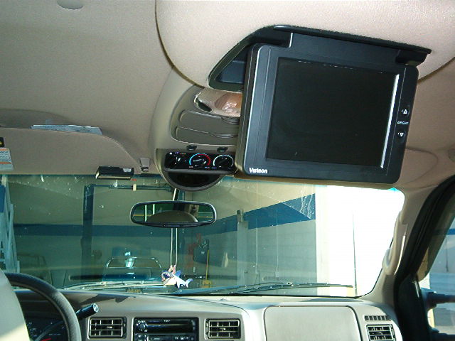 Interior view of a 2000 Ford Excursion with an overhead screen and climate controls