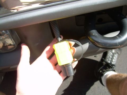 2002 Ford F-250 - Close-up of a trailer hitch wiring connector being held by a hand.