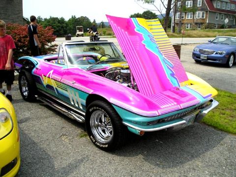 1984 Pontiac Fiero - A 1965 Chevrolet Corvette convertible displays a bold, retro graphic paint scheme with its hood raised, parked outdoors.