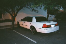 2001 Mercury Grand Marquis - A white 2001 Mercury Grand Marquis sedan is parked under trees at night.
