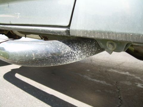 1992 Ford Bronco - Close-up view of a vehicle's exhaust pipe and undercarriage, showing some wear and residue.