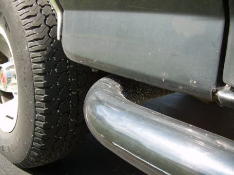 1992 Ford Bronco - Close-up view of a vehicle's side step and tire, with "SUPERMOTORS" visible on the lower right.