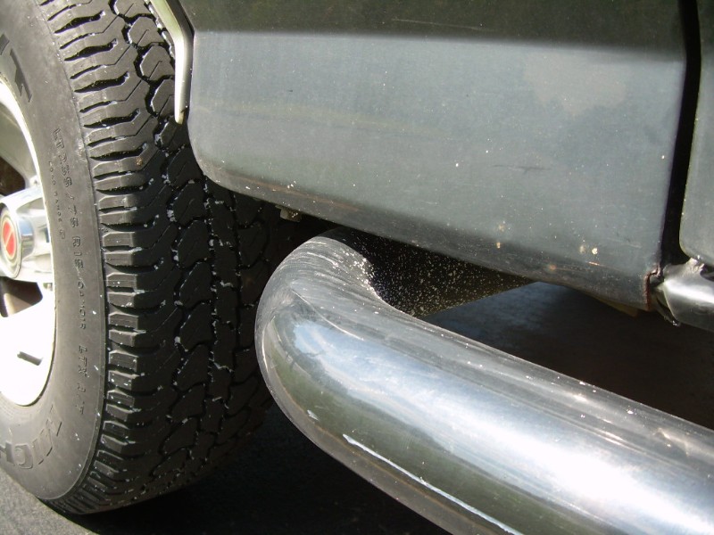 Side step and tire of a dark-colored vehicle