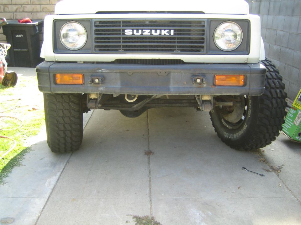 White Suzuki Samurai front view with black bumper and off-road tires