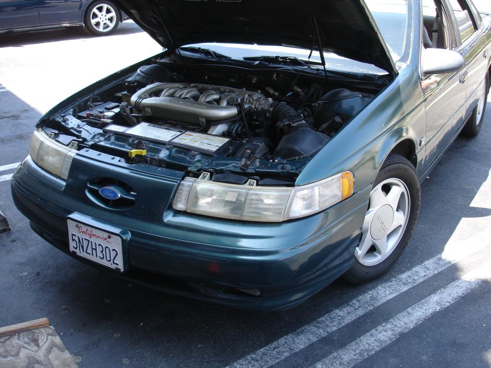 Green 1996 Ford Taurus with hood open, showing engine and California license plate 5NZH302