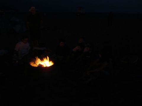 1995 Ford Taurus - A group of people enjoy a bonfire on the beach under the dark night sky.