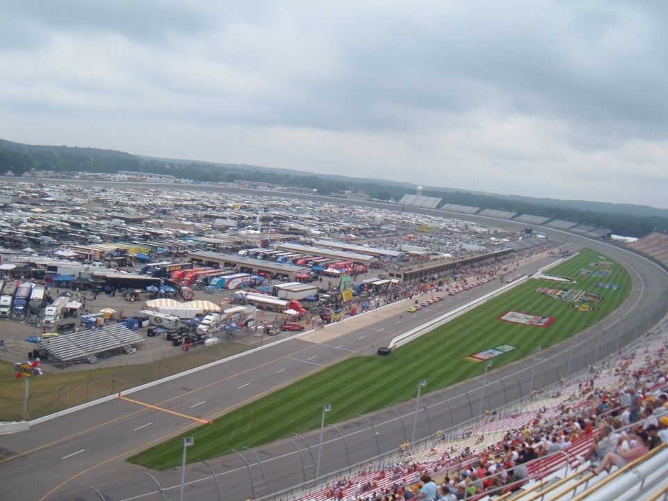 Race track parking lot filled with RVs and trailers under a cloudy sky