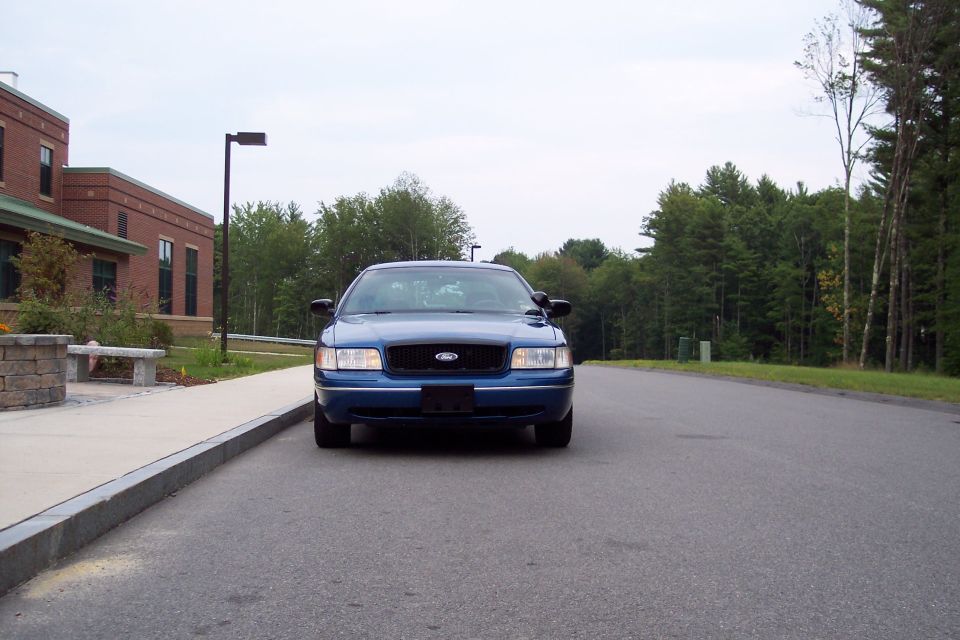 Blue 2001 Ford Crown Victoria parked on asphalt road, front view