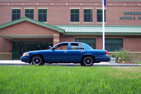 2001 Ford Crown Victoria - A blue 2001 Ford Crown Victoria is parked in front of Merrimack Middle School.