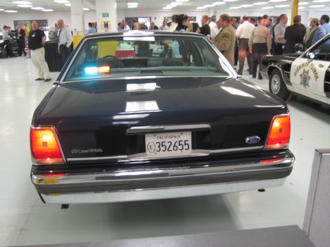 2001 Ford Crown Victoria - A dark blue sedan, identified as an LTD Crown Victoria, is parked indoors with police lights on its rear deck.