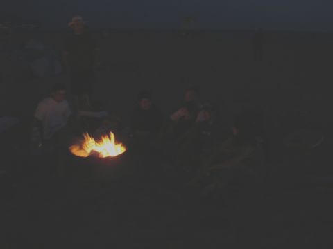 1995 Ford Taurus - Friends gather around a glowing campfire, enjoying the evening outdoors.