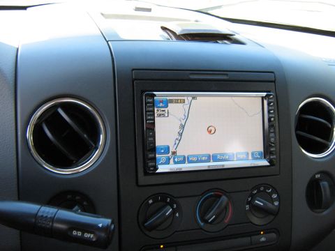 1986 Ford Bronco - Interior view of a car dashboard, displaying a GPS navigation system and climate controls.