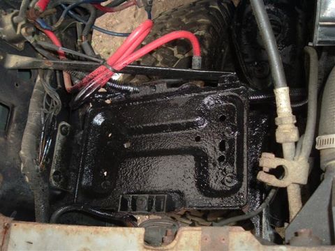 1991 Ford Bronco - Close-up view of the engine bay, focusing on the battery tray and associated wiring.