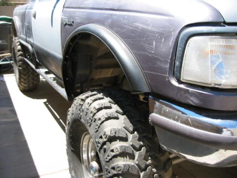 1997 Ford Ranger - Close-up of a 1997 Ford Ranger's front fender and aggressive off-road tire.