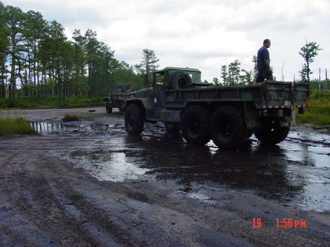 1995 Dodge 1500 - Military trucks navigate a muddy terrain under an overcast sky.