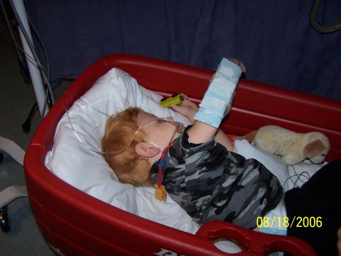 1979 Ford F-150 - Child rests in a red wagon with medical equipment and a stuffed dog.