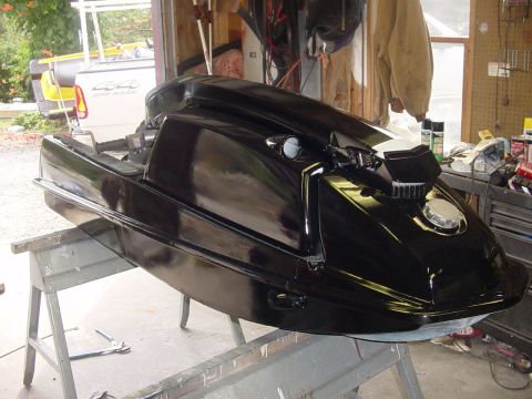 1995 Ford Mustang - A black personal watercraft is undergoing maintenance in a garage setting.