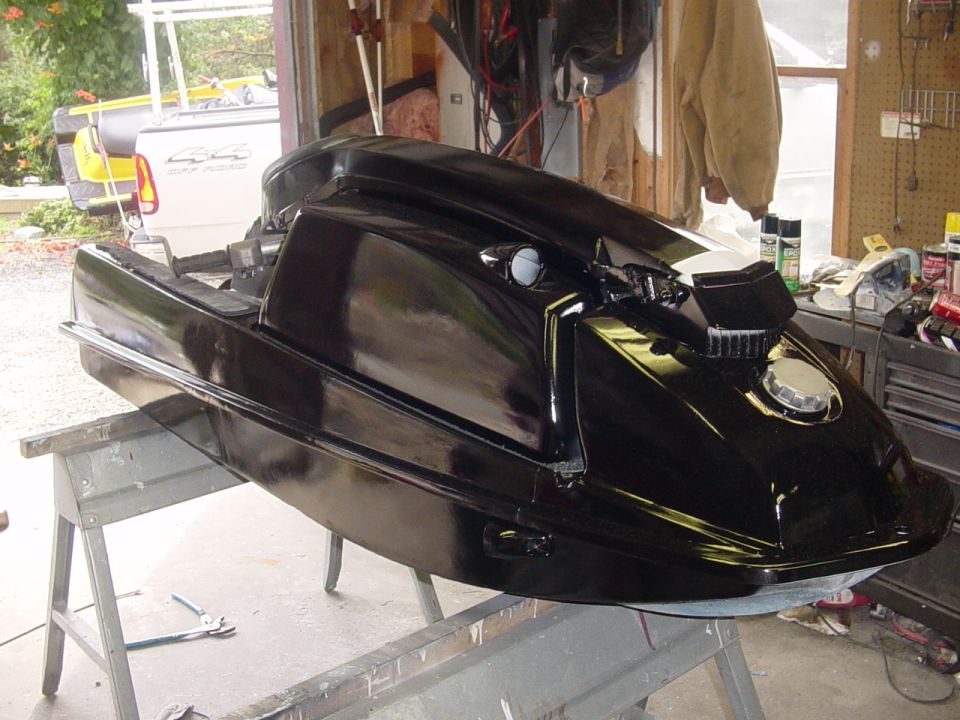 Black personal watercraft on sawhorses in a garage