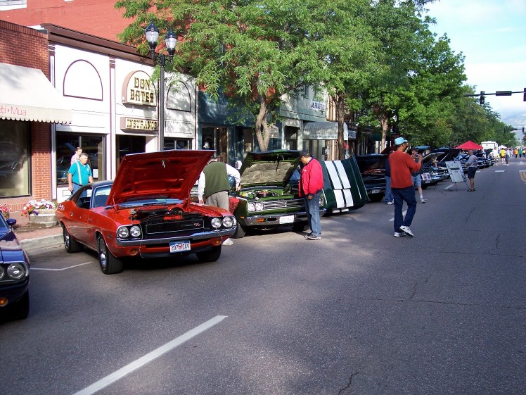 Red muscle car with hood open, showing engine. License plate visible