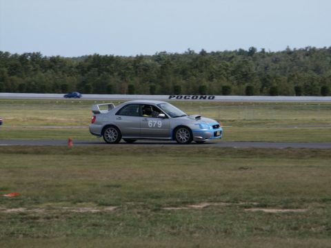 2001 Mercury Grand Marquis - A silver Subaru Impreza WRX STI, identified by the number 679, is seen on a race track with the 'POCONO' sign in the background.
