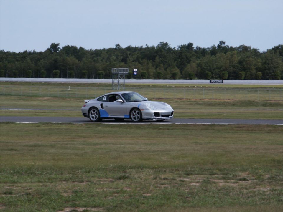 Silver Porsche 911 Turbo with blue racing stripes on a track