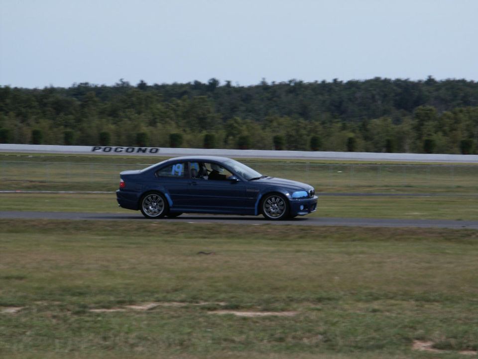 Blue coupe on racetrack with 'POCONO' sign