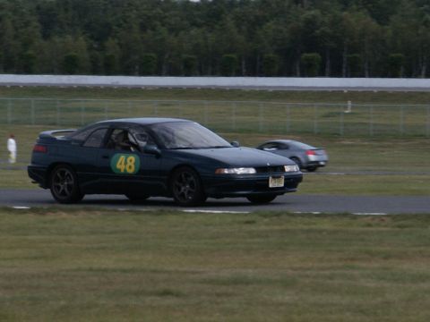 2001 Mercury Grand Marquis - Two cars on a race track, one in the foreground with number 48 on its door.