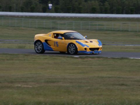 2001 Mercury Grand Marquis - A yellow and blue sports car, marked with the number 15, drives on a race track.