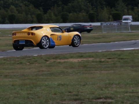 2001 Mercury Grand Marquis - A yellow sports car is on the track, with another vehicle in the distance.