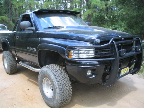 1990 Ford Bronco - This black pickup truck features a prominent bull bar and large off-road tires, suggesting it is built for terrain.