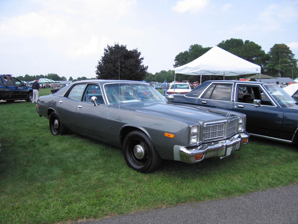 Gray 1977 Dodge Monaco sedan parked on grass, another dark sedan behind it