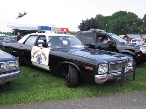 2001 Ford Crown Victoria - This vintage highway patrol car, likely from the mid-1970s, is parked next to a modern SUV.