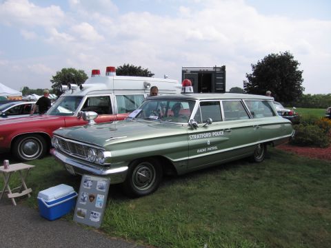 2001 Ford Crown Victoria - A 1963 Ford Country Sedan station wagon marked as Stratford Police Radio Patrol is displayed outdoors.