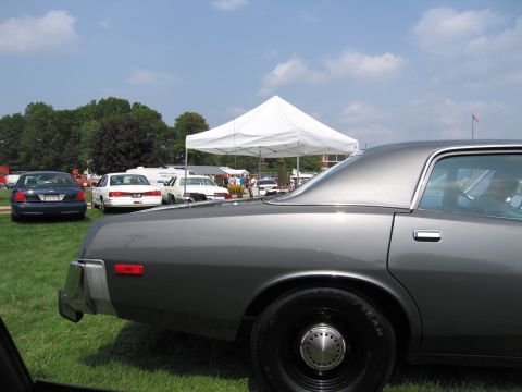 2001 Ford Crown Victoria - A gray sedan is parked on a grassy field with a white tent and other vehicles visible.