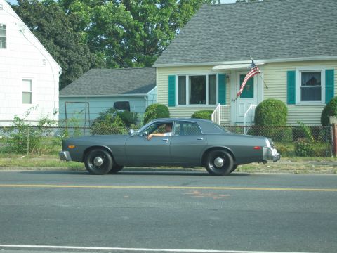 2001 Ford Crown Victoria - A side view of a vintage sedan parked on the street.