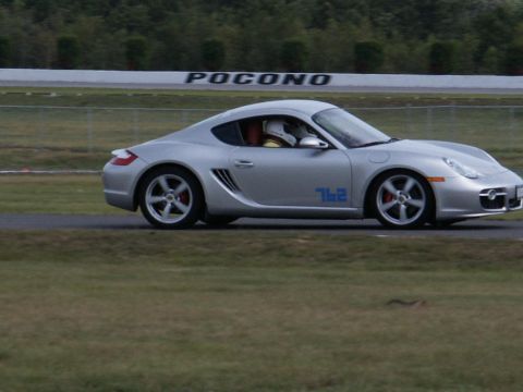 2001 Mercury Grand Marquis - A silver Porsche Cayman with the number 762 on its side drives on a race track with 'POCONO' visible in the background.