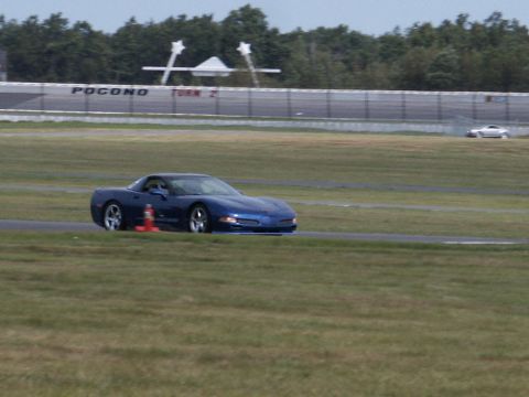 2001 Mercury Grand Marquis - Blue Chevrolet Corvette C5 driving on the Pocono Raceway track.