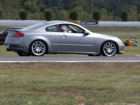 2001 Mercury Grand Marquis - A silver coupe with racing number 405 is on a race track with a driver wearing a helmet.