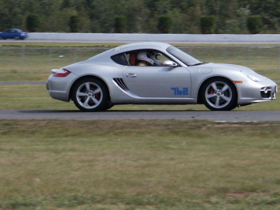 Silver Porsche Cayman with blue '762' graphic on side, on a race track