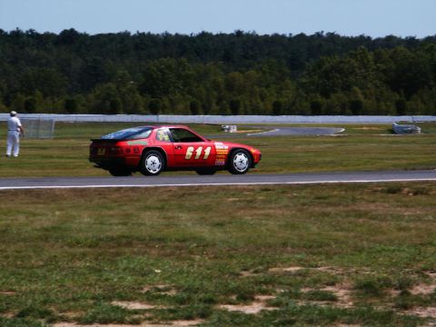 2001 Mercury Grand Marquis - A red sports car with racing decals and the number 611 is seen on a race track.