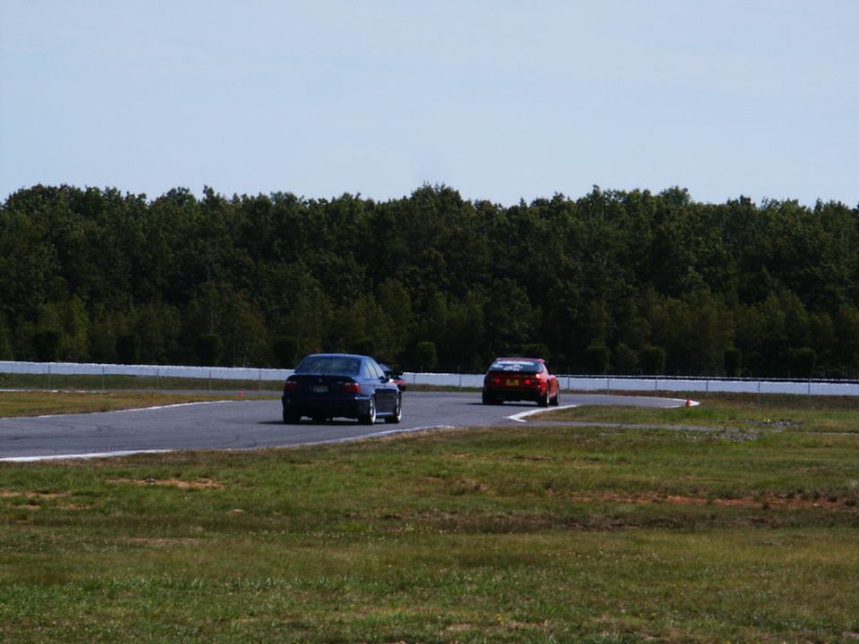 Blue sedan and red sports car on a racetrack