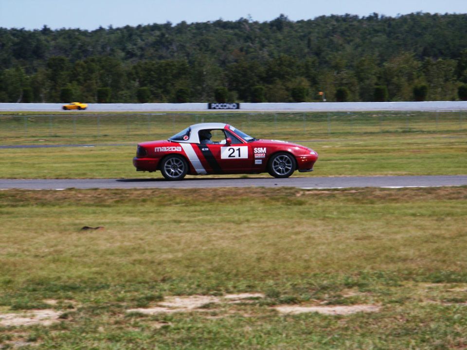 Red Mazda Miata with racing number 21 on track