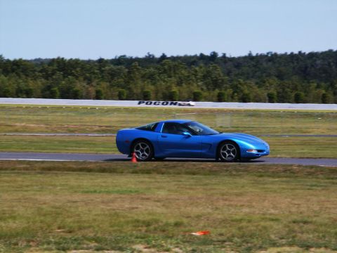 2001 Mercury Grand Marquis - A blue Chevrolet Corvette C5 is seen on a racetrack, with the word 'Pocono' visible on a distant sign.