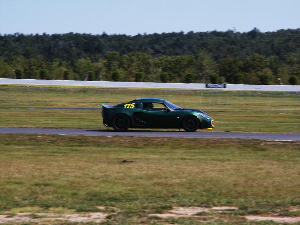 Green sports car with yellow number 175 on the side, on a race track