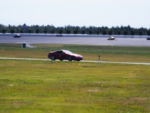 2001 Mercury Grand Marquis - A red coupe with racing number 8 is seen on a racetrack with other vehicles in the background.