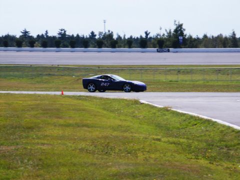 2001 Mercury Grand Marquis - A dark blue sports car, identified by the number 247 on its door, is seen on a race track during a sunny day.