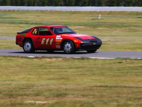 2001 Mercury Grand Marquis - A red race car numbered 611 speeds around a track, displaying various sponsor decals.