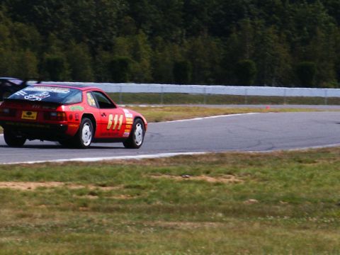 2001 Mercury Grand Marquis - A red race car with the number 611 displayed prominently on its side navigates a turn on a race track.